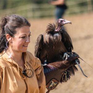 Falconiera in costume con un avvoltoio sul guanto